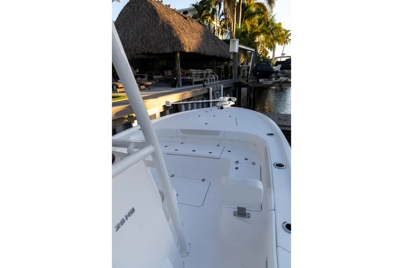 Slide: The Image of 2022 Caymas 28 HB Twin boat docked near a thatched-roof structure and palm trees. - 11