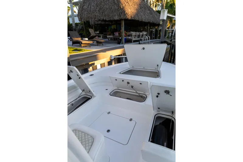 Slide: The Image of 2022 Caymas 28 HB Twin boat with open storage compartments, dockside view. - 13
