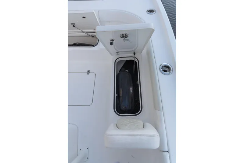 Slide: The Image of 2022 Caymas 28 HB Twin boat storage compartment with open hatch and cushioned seat. - 14
