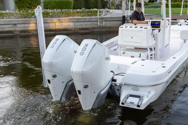 Slide: The Image of 2022 Caymas 28 HB Twin boat with dual Mercury 300 engines in a canal setting. - 2
