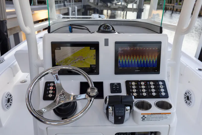 Slide: The Image of 2022 Caymas 28 HB Twin boat dashboard with dual Garmin displays and steering wheel. - 23