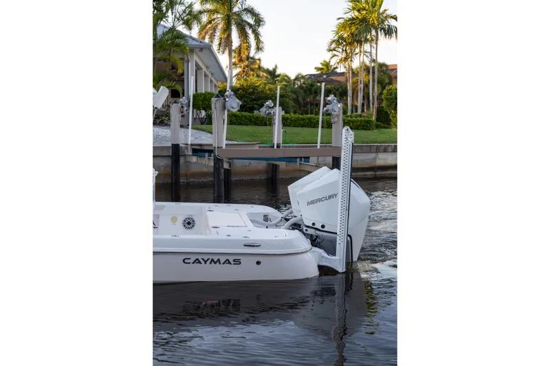 Slide: The Image of 2022 Caymas 28 HB Twin boat docked with Mercury engines, surrounded by tropical scenery. - 25