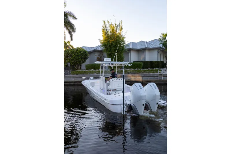 Slide: The Image of 2022 Caymas 28 HB Twin boat cruising on a calm waterway near residential area. - 26