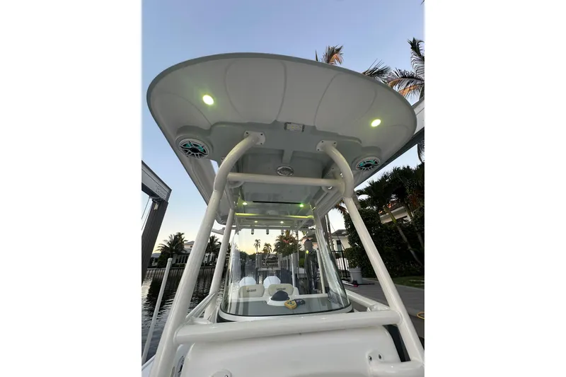 Slide: The Image of 2022 Caymas 28 HB Twin boat with illuminated canopy and speakers at sunset. - 29