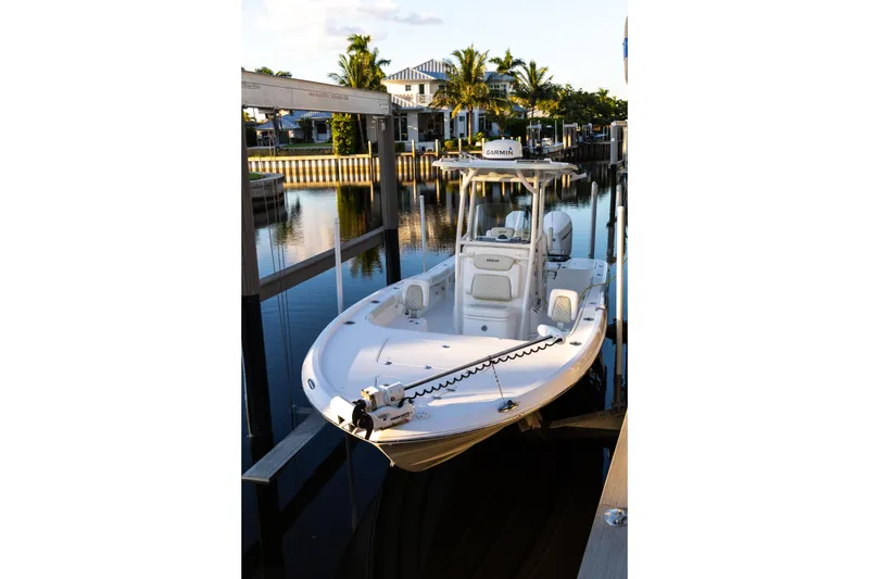 Slide: The Image of 2022 Caymas 28 HB Twin boat docked in a serene marina setting. - 3