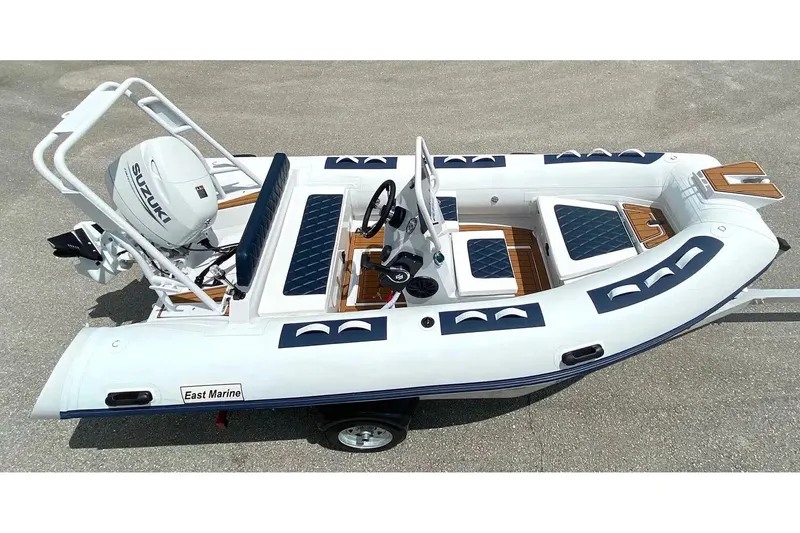 Slide: The Image of Manufacturer Provided Image: 2025 East Marine 420 inflatable boat with Suzuki outboard motor, featuring sleek design and seating. - 1