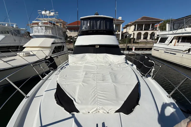 Slide: The Image of 1991 Californian 55 Cockpit Motor Yacht docked, showcasing sleek design and windows. - 11