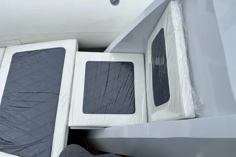 Slide: The Image of East Marine 560 boat interior seating, 2026 model, with protective plastic covering. - 14