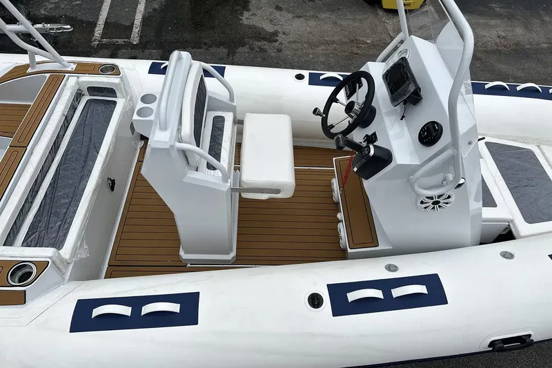 Slide: The Image of Manufacturer Provided Image: 2025 East Marine 560 boat interior with steering console and seating, featuring wood-style flooring. - 5