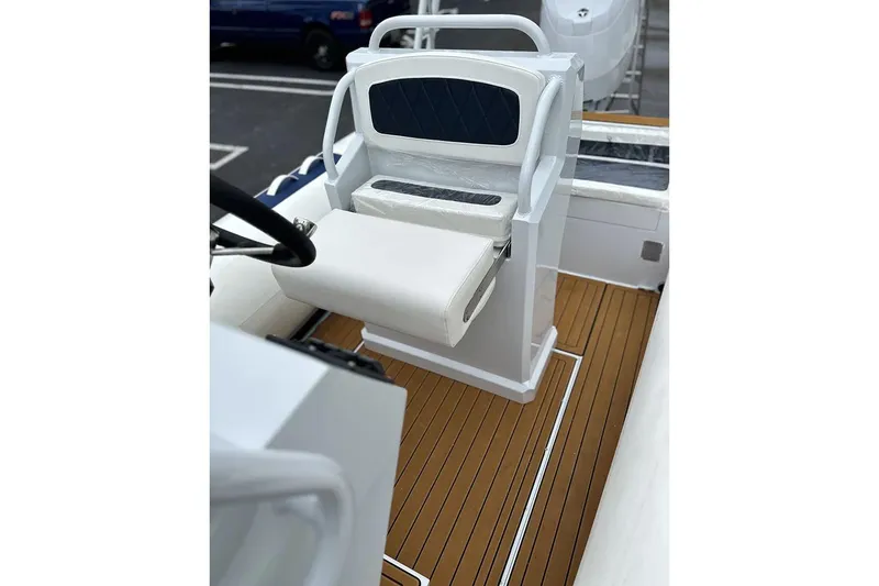 Slide: The Image of Manufacturer Provided Image: 2025 East Marine 560 boat interior with white seating and wooden deck. - 6