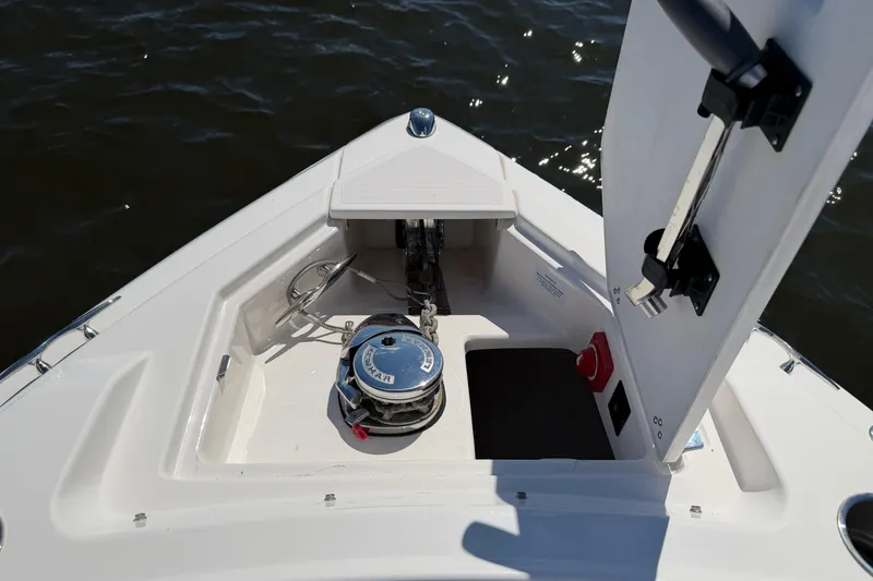 Slide: The Image of 2021 Regal 33 SAV boat anchor compartment with open hatch, showing winch and storage. - 10