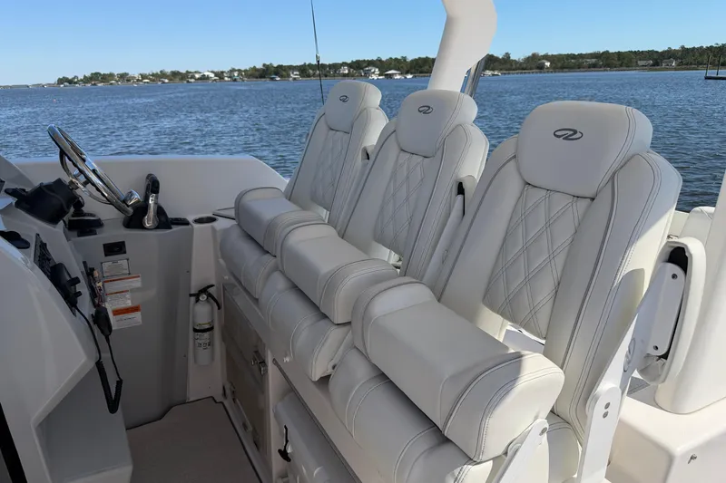 Slide: The Image of 2021 Regal 33 SAV boat interior with luxurious white seating and steering wheel. - 11