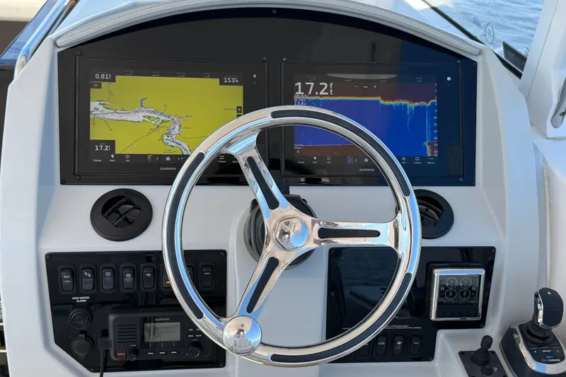 Slide: The Image of 2021 Regal 33 SAV boat dashboard with Garmin navigation displays and steering wheel. - 12