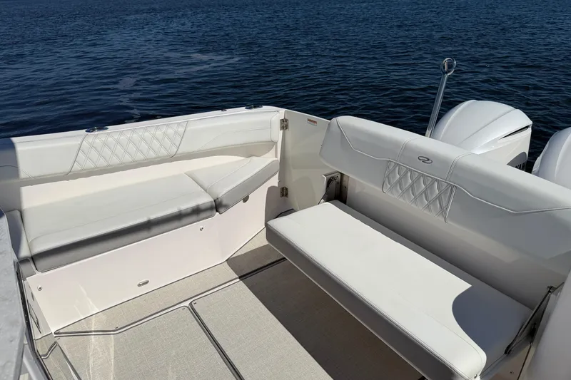 Slide: The Image of 2021 Regal 33 SAV boat interior with white seating, on calm water. - 20