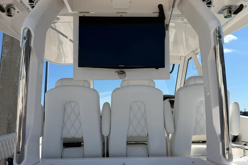 Slide: The Image of 2021 Regal 33 SAV boat interior with white seating and mounted TV screen. - 23