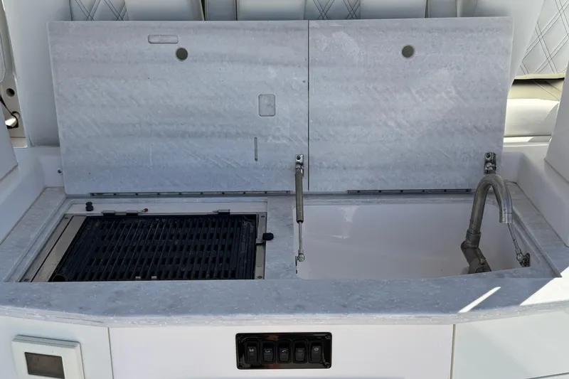 Slide: The Image of 2021 Regal 33 SAV boat kitchen area with grill and sink. - 26