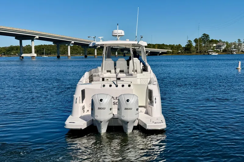 Slide: The Image of 2021 Regal 33 SAV boat on water near a bridge, featuring dual outboard engines. - 3