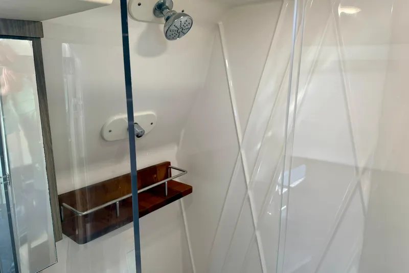 Slide: The Image of Shower area in 2021 Regal 33 SAV boat with glass door and wooden shelf. - 31