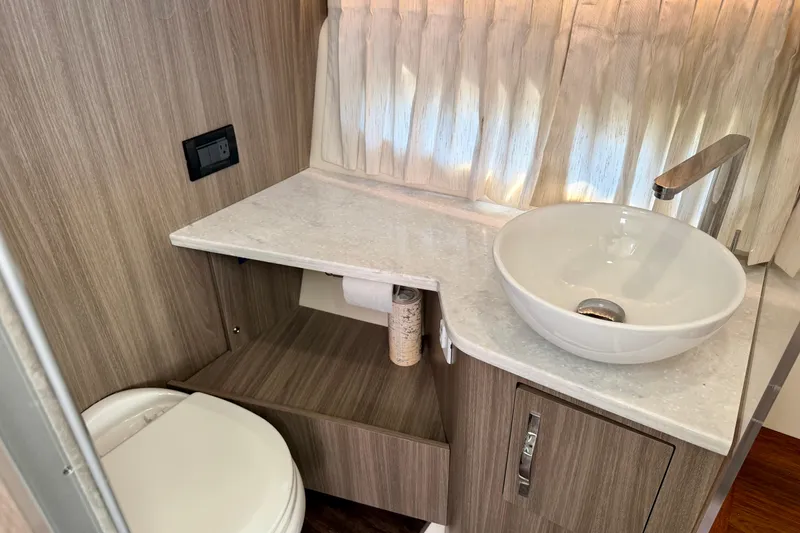 Slide: The Image of Modern bathroom in 2021 Regal 33 SAV boat with vessel sink and wood accents. - 32