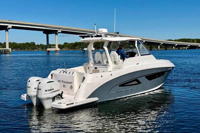 Slide: The Image of 2021 Regal 33 SAV boat on water near bridge, featuring dual Yamaha engines. - 4