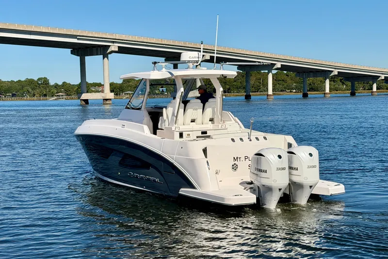 Slide: The Image of 2021 Regal 33 SAV boat cruising under a bridge on a sunny day. - 5