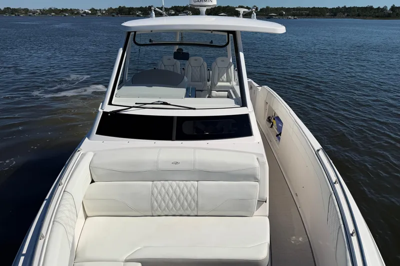 Slide: The Image of 2021 Regal 33 SAV boat with white seating on calm water. - 7