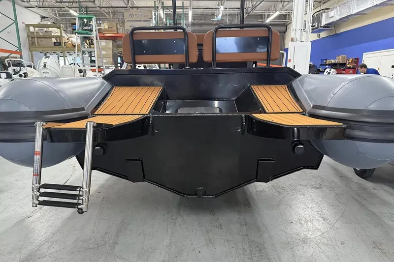 Slide: The Image of Manufacturer Provided Image: 2025 East Marine 700 boat with wooden deck and ladder in a warehouse setting. - 11
