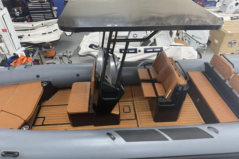 Slide: The Image of Manufacturer Provided Image: East Marine 700 boat interior, 2025 model, featuring brown seating and sleek design. - 2