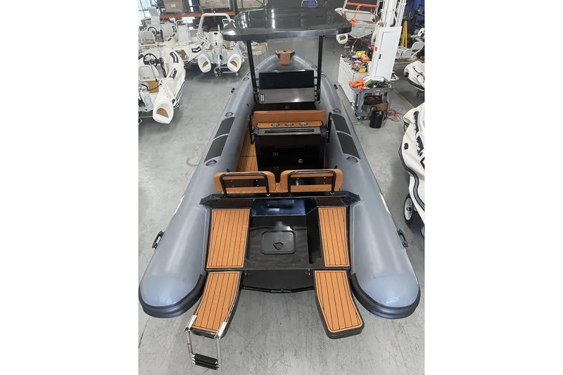 Slide: The Image of Manufacturer Provided Image: 2025 East Marine 700 boat with sleek design and wooden deck accents in a showroom. - 4