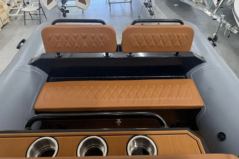 Slide: The Image of Manufacturer Provided Image: 2025 East Marine 700 boat interior with tan quilted seats and cup holders. - 9