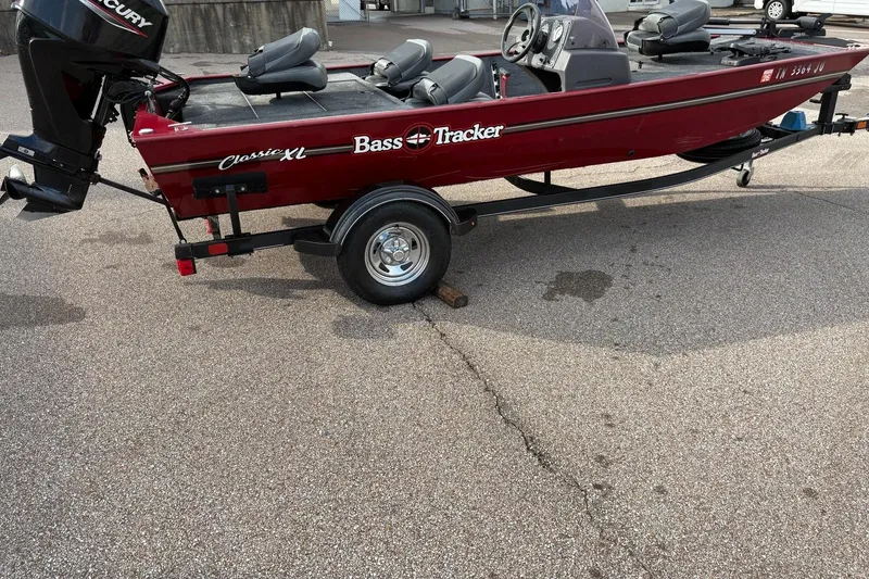 Slide: The Image of 2020 Tracker Bass Tracker Classic XL boat on trailer, red color, parked outdoors. - 2