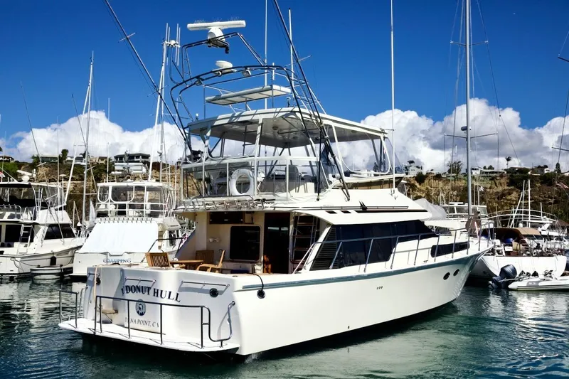 Slide: The Image of 2002 Mikelson 50 Sportfisher yacht docked in a marina under clear blue skies. - 10