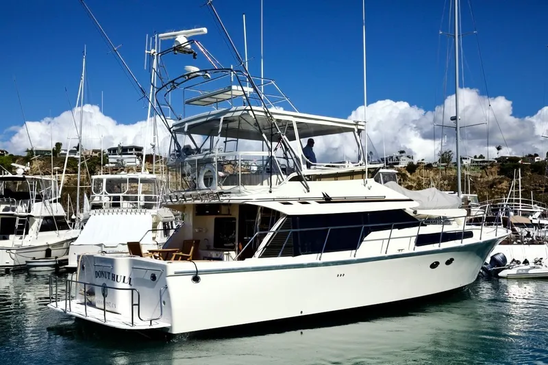 Slide: The Image of 2002 Mikelson 50 Sportfisher yacht docked in a marina under clear blue skies. - 11