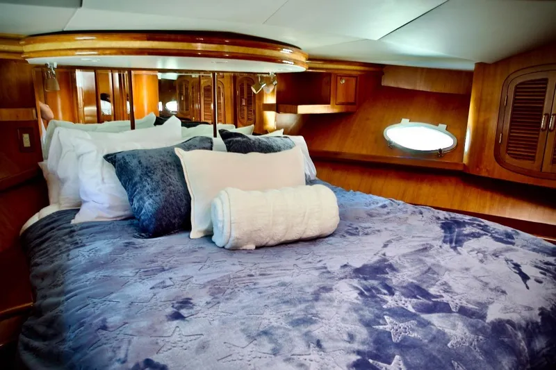 Slide: The Image of Luxurious cabin interior of 2002 Mikelson 50 Sportfisher with plush bedding and wood accents. - 14