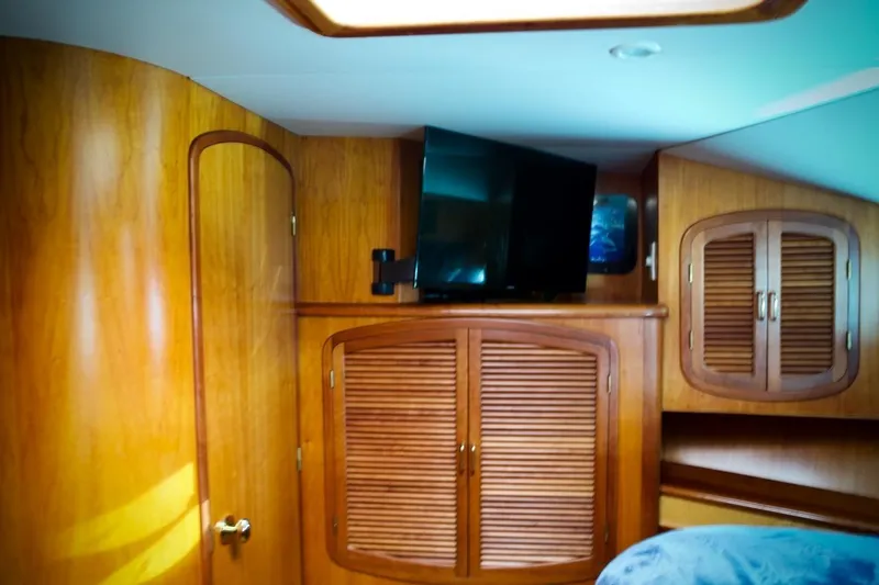 Slide: The Image of Interior of 2002 Mikelson 50 Sportfisher with wooden cabinets and mounted TV. - 19