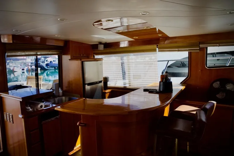 Slide: The Image of Luxurious interior of 2002 Mikelson 50 Sportfisher yacht with wooden bar and marina view. - 20