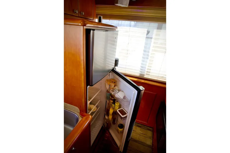 Slide: The Image of Open refrigerator inside 2002 Mikelson 50 Sportfisher yacht kitchen area. - 28