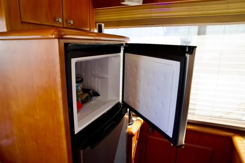 Slide: The Image of Open freezer in 2002 Mikelson 50 Sportfisher yacht interior, wooden cabinetry visible. - 29
