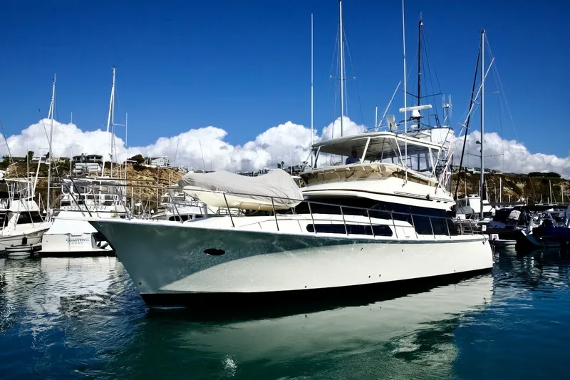 Slide: The Image of 2002 Mikelson 50 Sportfisher yacht docked in a marina under clear blue skies. - 3