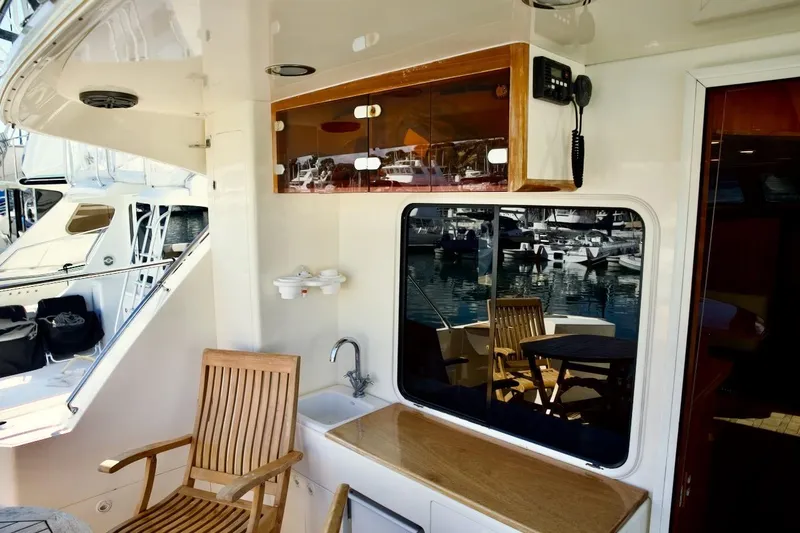 Slide: The Image of 2002 Mikelson 50 Sportfisher yacht interior with wooden chair, sink, and marina view. - 34