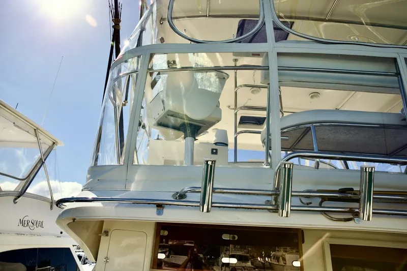 Slide: The Image of 2002 Mikelson 50 Sportfisher yacht with upper deck and clear enclosure under sunny sky. - 39
