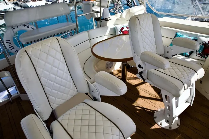 Slide: The Image of Luxurious seating on 2002 Mikelson 50 Sportfisher yacht with white quilted chairs and wooden deck. - 45