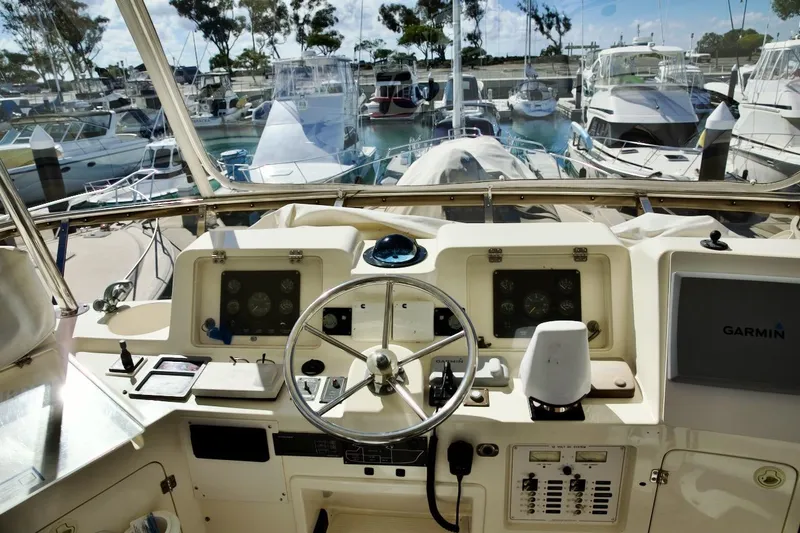 Slide: The Image of Helm of 2002 Mikelson 50 Sportfisher with Garmin navigation, docked among other boats. - 50