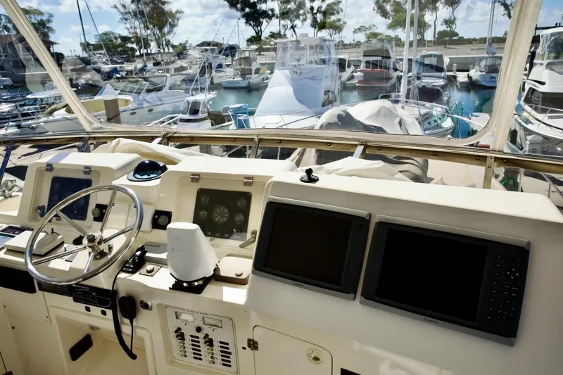 Slide: The Image of Helm of 2002 Mikelson 50 Sportfisher yacht with marina view. - 52
