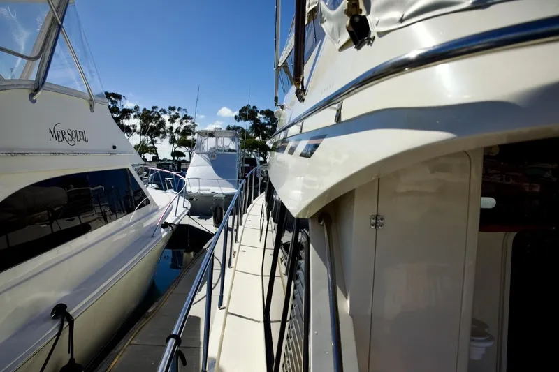 Slide: The Image of 2002 Mikelson 50 Sportfisher yacht docked alongside other boats in a marina. - 54