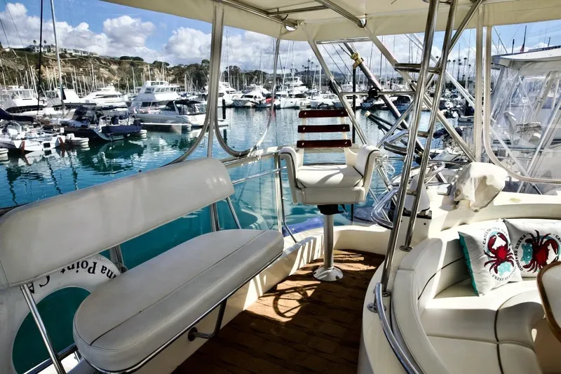 Slide: The Image of Luxurious 2002 Mikelson 50 Sportfisher yacht interior at marina, featuring plush seating and scenic views. - 60