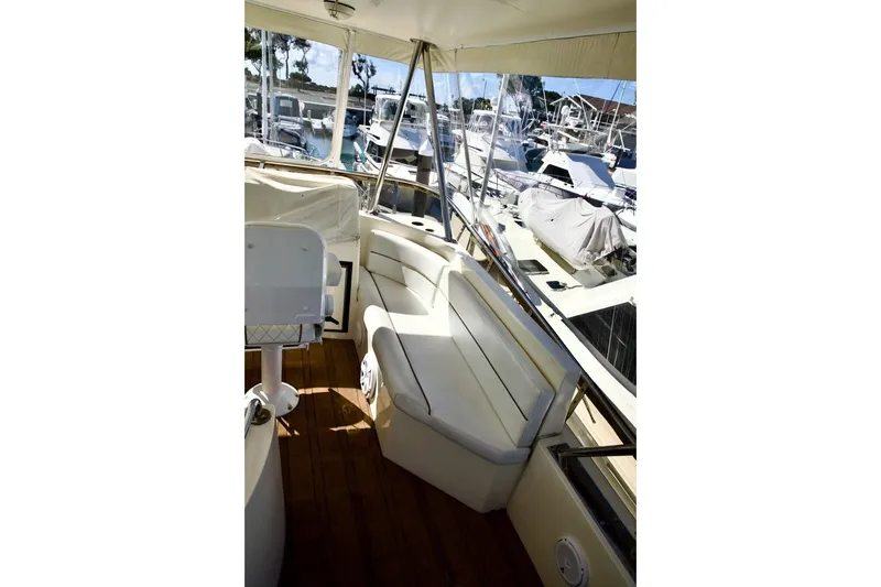 Slide: The Image of 2002 Mikelson 50 Sportfisher yacht interior with seating and marina view. - 62