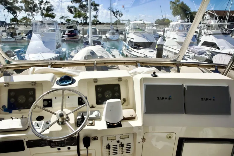 Slide: The Image of Cockpit view of 2002 Mikelson 50 Sportfisher with Garmin navigation, docked among other boats. - 65