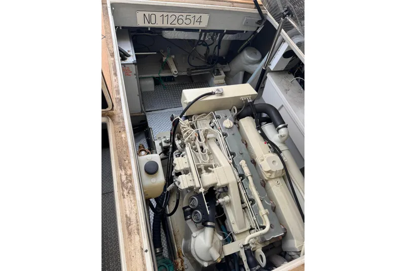 Slide: The Image of Engine compartment of a 2002 Mikelson 50 Sportfisher boat, showcasing detailed machinery. - 73