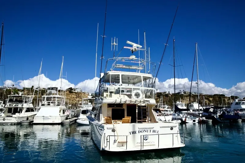Slide: The Image of Mikelson 50 Sportfisher 2002 yacht docked in a marina under clear blue skies. - 8